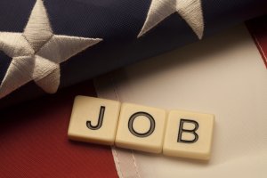 Dice forming a word ‘JOB’ and lying on an american flag