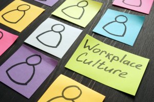 Colorful sticky notes on a dark surface, each with a simple outline of a person. One blue sticky note stands out, displaying the text "Workplace Culture" in bold, black letters. The notes highlight the concept of individuality within the workplace environment.
