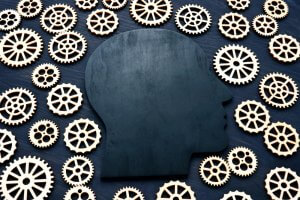 A silhouette of a head surrounded by many little gears