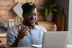 Happy young man having likely an online meeting