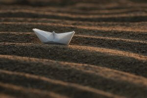 A white paper boat on the sand