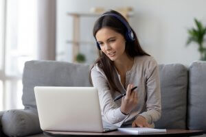 A young woman with headphones on having an online meeting
