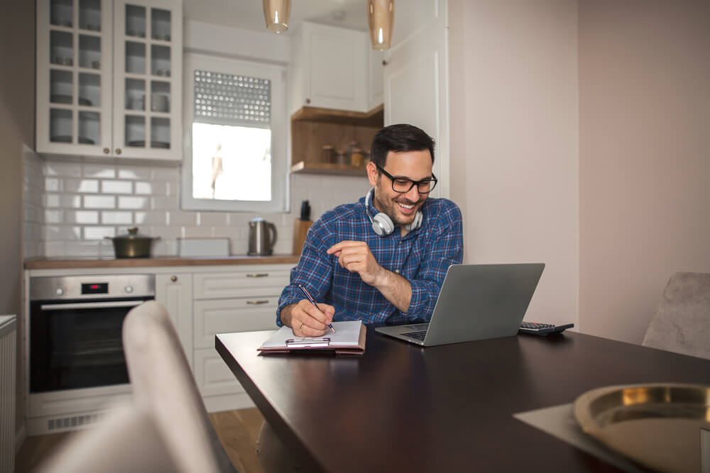 Young,Smiling,Businessman,Working,From,Home,Writing,Notes,In,Notebook women's leadership