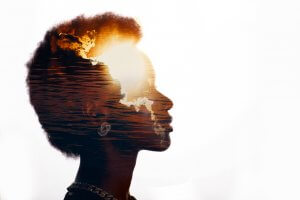 A double exposure image shows the silhouette of a person with short, curly hair, filled with an orange sunset over a calm body of water. The sun and a few clouds emphasize a peaceful, contemplative atmosphere—a perfect visual representation for someone deep in thought during their job search journey.