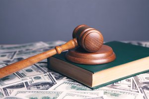 A gavel, a green book and dollar bills