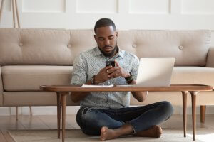 An African American man sitting on the floor with legs crossed