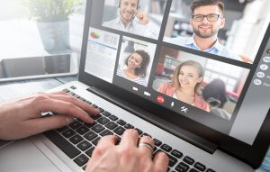 A close up of a laptop with an online meeting on the screen