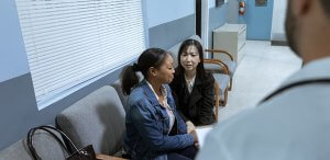 Two worried women sitting in a waiting room