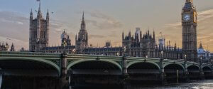 Panoramic view of the Palace of Westminster and the iconic clock tower known as Big Ben in London, England. The image features the Gothic-style buildings and the Westminster Bridge over the River Thames at dusk, with a clear sky and subdued lighting—a scene far removed from learning how to find high-paying government jobs in Phoenix.