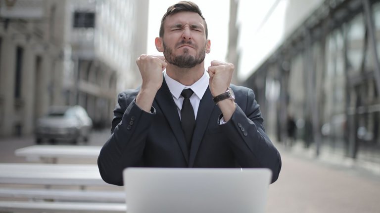A man in front of laptop jubilating