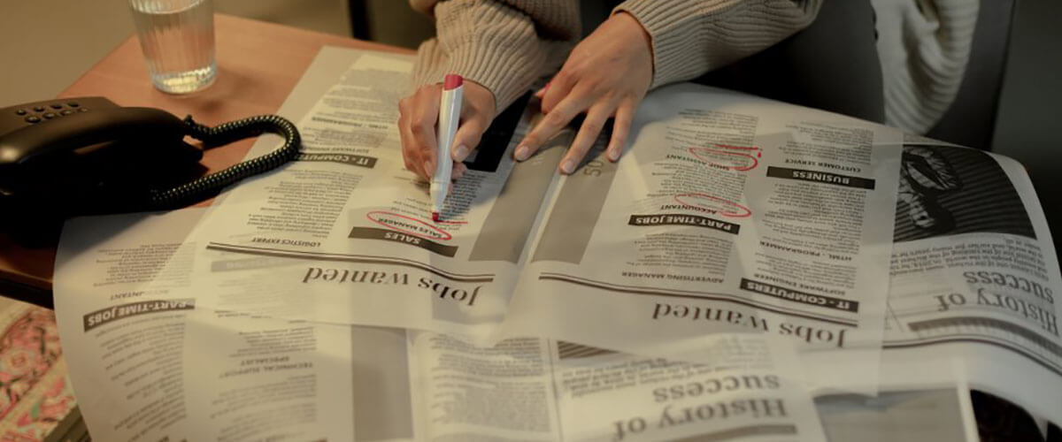 A woman searching for job in a newspaper