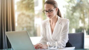 Concentrated female entrepreneur typing on laptop in workplace Montana