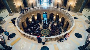 A wide-angle view from above of a large, ornate rotunda in a government building, where people gather near the center. The architecture features columns, marble floors, and a decorative railing encircling the rotunda—an iconic spot often visited by those seeking easy ways to find government jobs in Tampa.