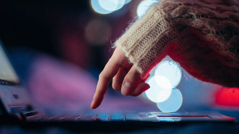 Image of a person's finger about to press a key on the laptop Arizona