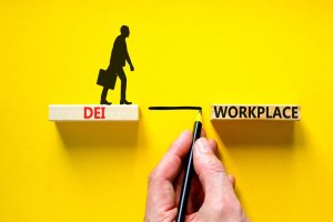 Illustration showing a person walking on wooden blocks. One block has "DEI" written and another says "WORKPLACE." A hand is drawing a line connecting the two blocks, symbolizing bridging the gap between Diversity, Equity, and Inclusion (DEI) and the hybrid workplace.