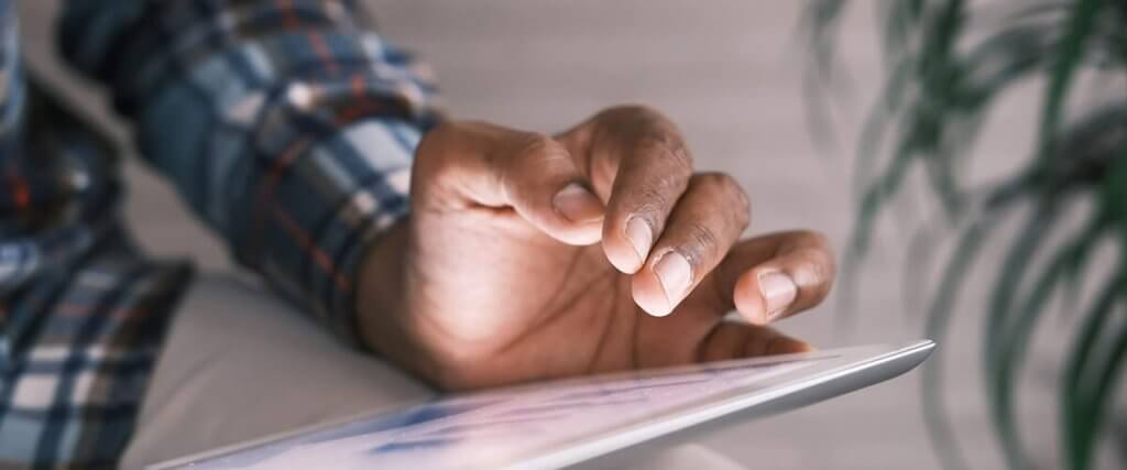 A hand holding a tablet