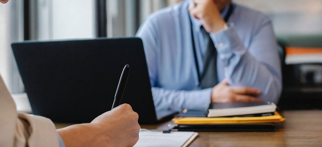 A person writing in front of another