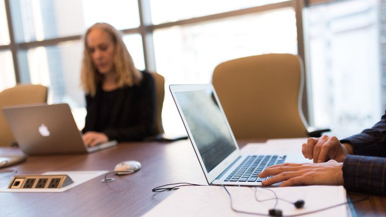 People pressing laptops in an office space