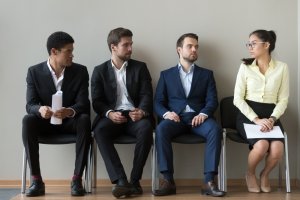 Male and female applicants sitting on a work bench