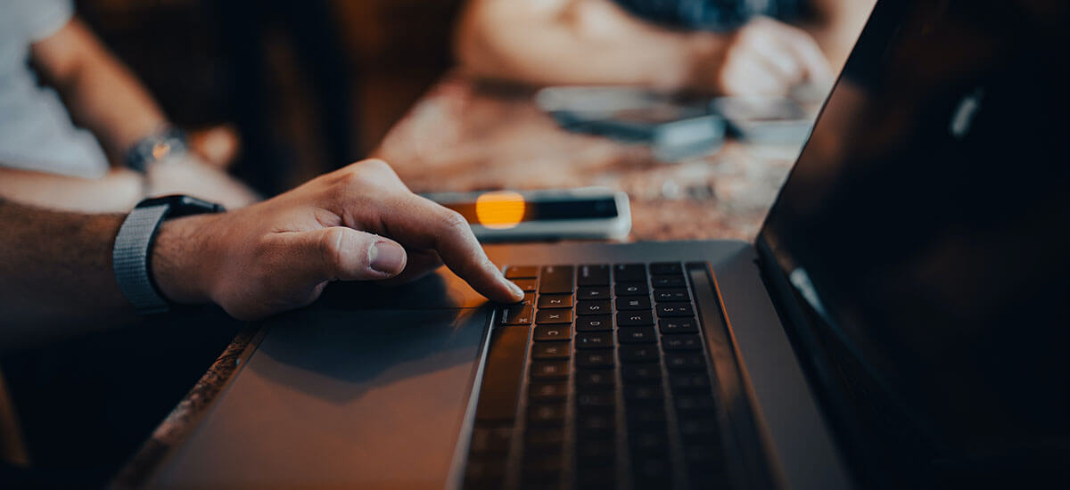 A hand on a laptop keyboard