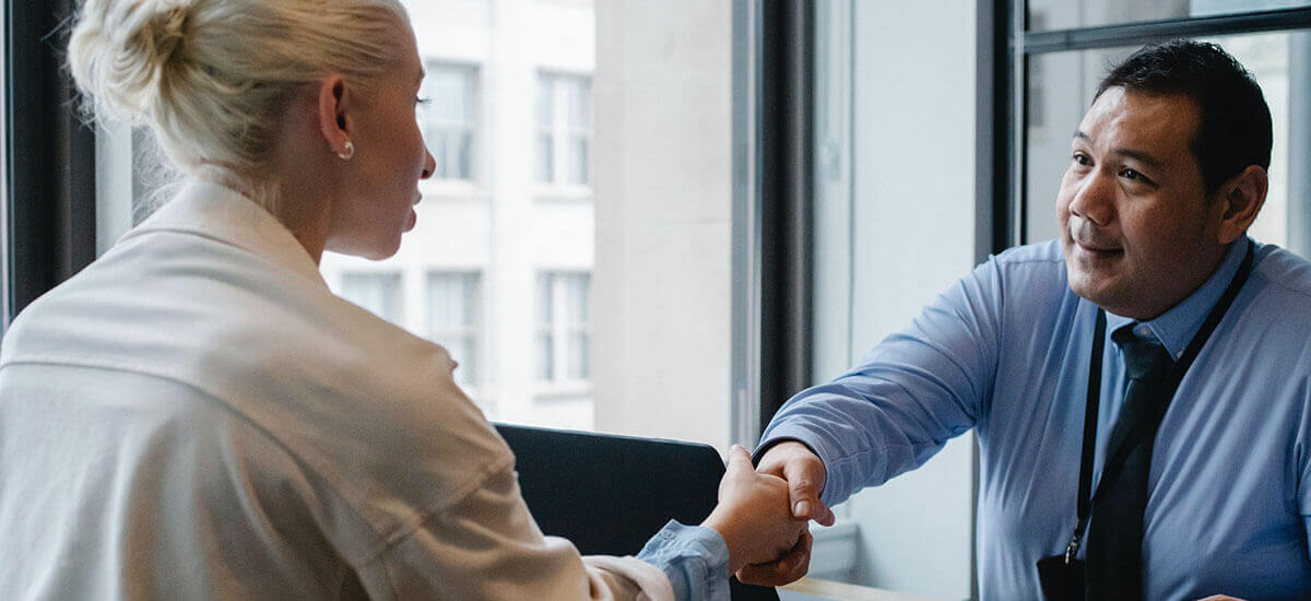 A male employer shaking hands with a lady