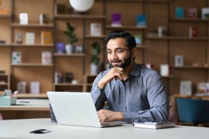 A man thinking in front of a laptop
