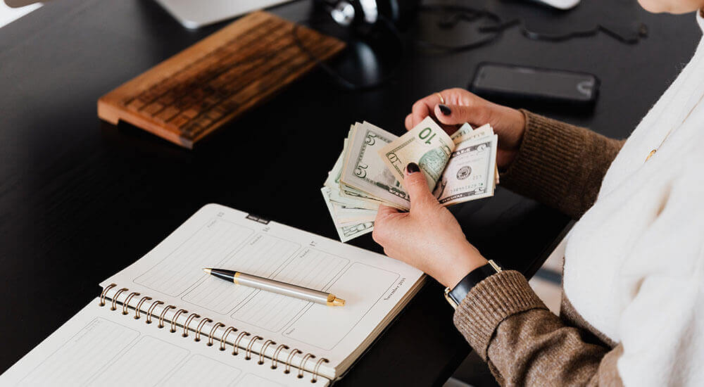 A person counting money - Santa Clara County