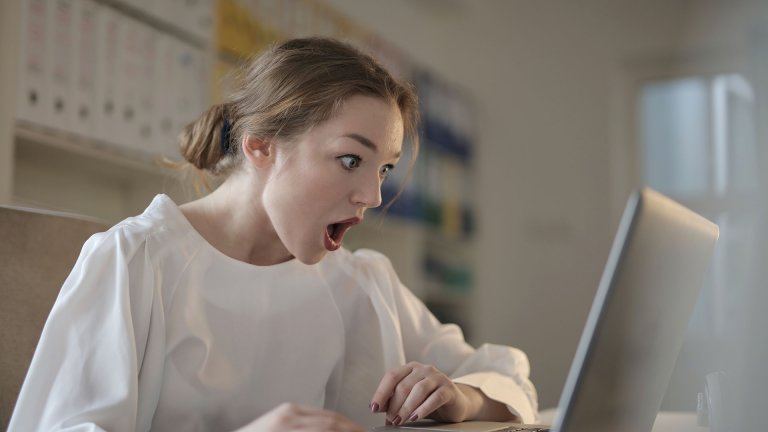 A girl expressing shock in front of a computer - Pima County - Careers In Government