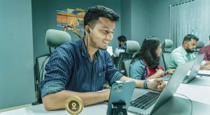 People working in the office in front of a laptop and a one man with phone