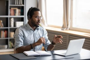 A man wearing headphones discussing online