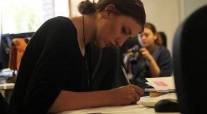 A woman seriously studying and writing