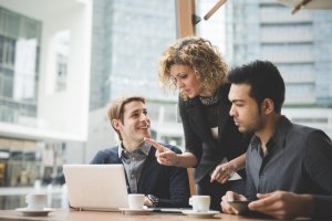 Three people discussing business matters outside office