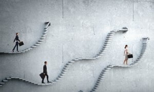 Three businesspeople, each holding a briefcase, walk up different winding staircases made of concrete against a grey wall. The staircases appear to defy gravity, creating an abstract and surreal environment that echoes the relentless labor of climbing corporate ladders.