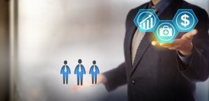 A person in a suit with icons above their hands. In the left hand are three figures representing people. In the right hand are hexagonal icons depicting growth, healthcare, and a dollar sign. The background is blurred and professional-looking, emphasizing a focus on healthcare advancements and economic growth.
