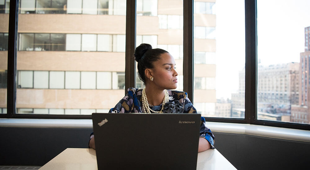 A woman in front of a laptop looking sideways - Charleston County - Careers In Government