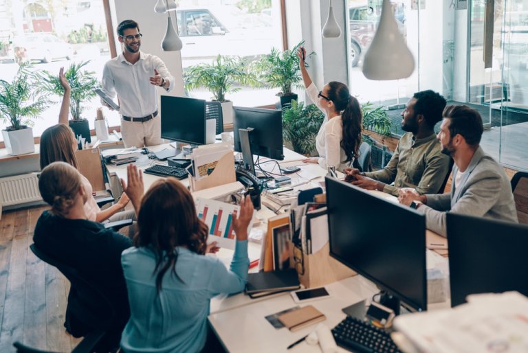 Group of young people in a smart casual wear communicating in an office