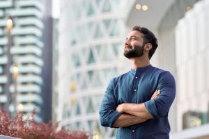 A confident rich Eastern Indian Business man proudly standing