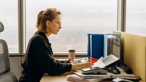 A female employee in an office is focused in doing her job in a laptop