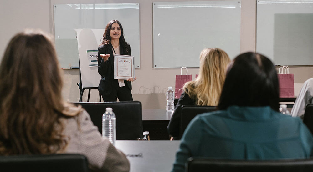 A woman speaking at an event - Harry Country - Careers In Government