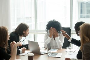 Diverse team humiliating and offending a young African woman