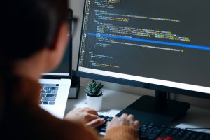 A woman programmer or developer working on codes in a desktop