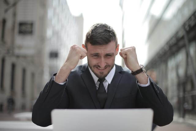 A man infront of a computer win something - Careers In Government