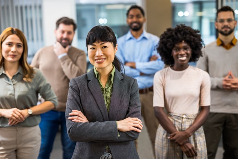 Asian boss standing in front of her colleagues in an office setting