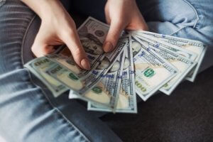 A person holding and counting her salary
