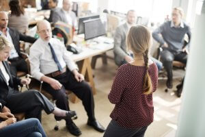 Woman leading a meeting in the office with other business people listening