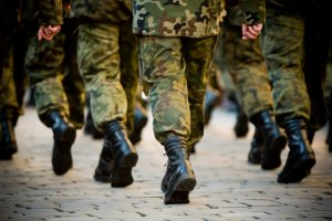 A group of soldiers in uniform march in formation