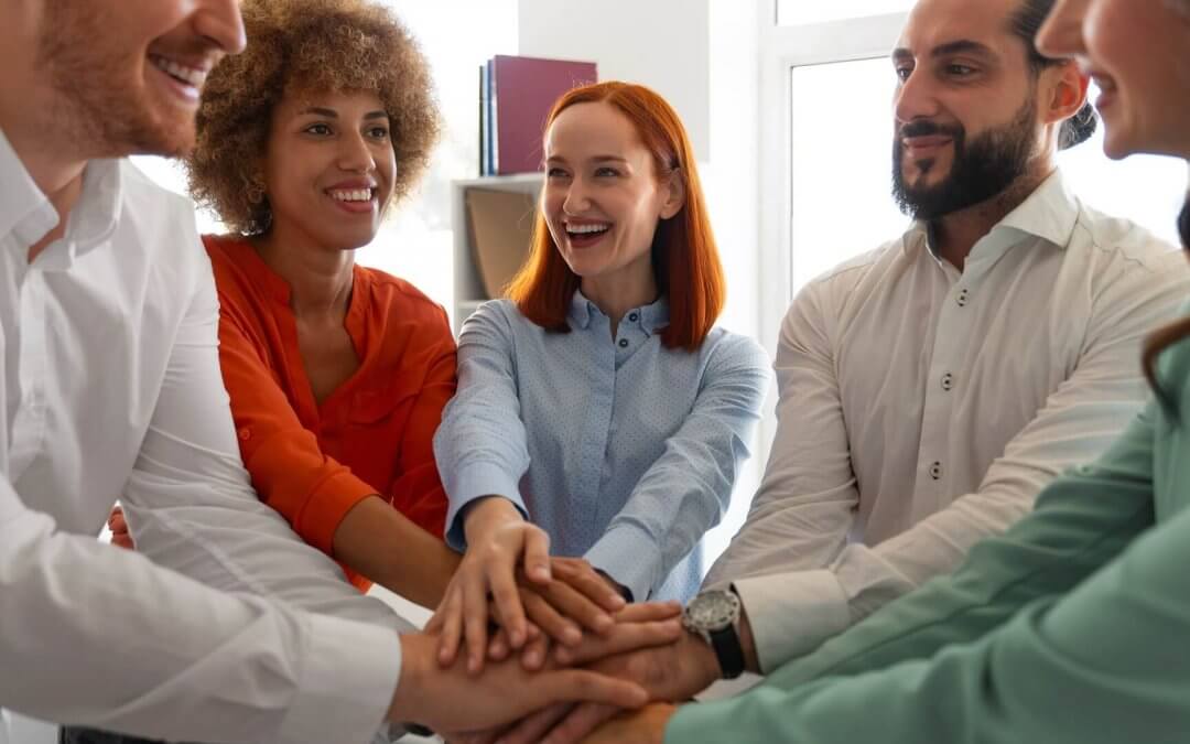 A group of people taking happily taking an oath puting palms together