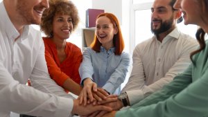 A group of people taking happily taking an oath putting palms together