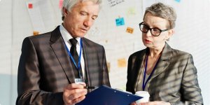 An old man and woman employee checking file together