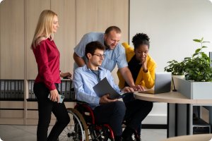 A disabled man and his team checking something on the laptop